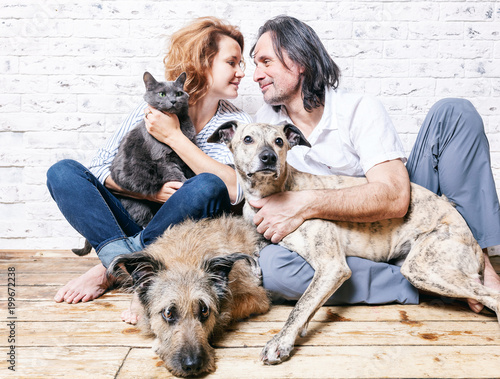 Photography Attractive man and his young wife with pets, two dogs and a cat, a family portra