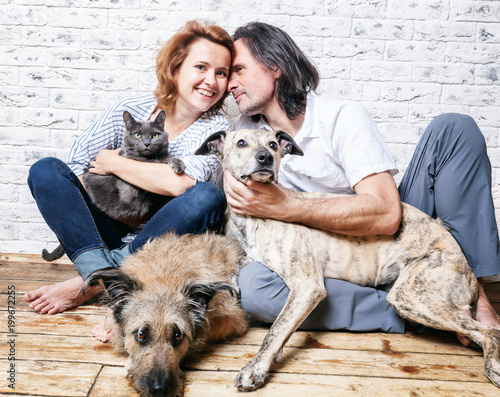 Photography Attractive man and his young wife with pets, two dogs and a cat, a family portra