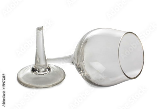 Broken glass and spilled red wine on white background