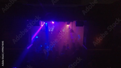 Smoky dance floor of an underground techno club with rays of light