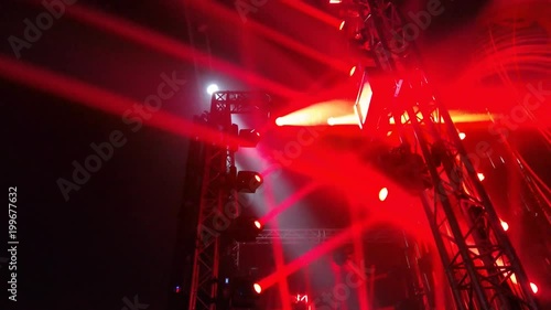 Side view to scene with a light show of many red rotating lights and stroboscope