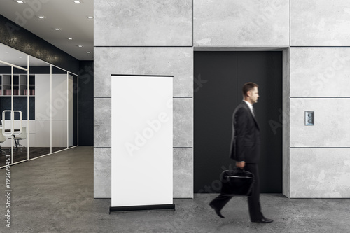 Man in office with elevator and poster