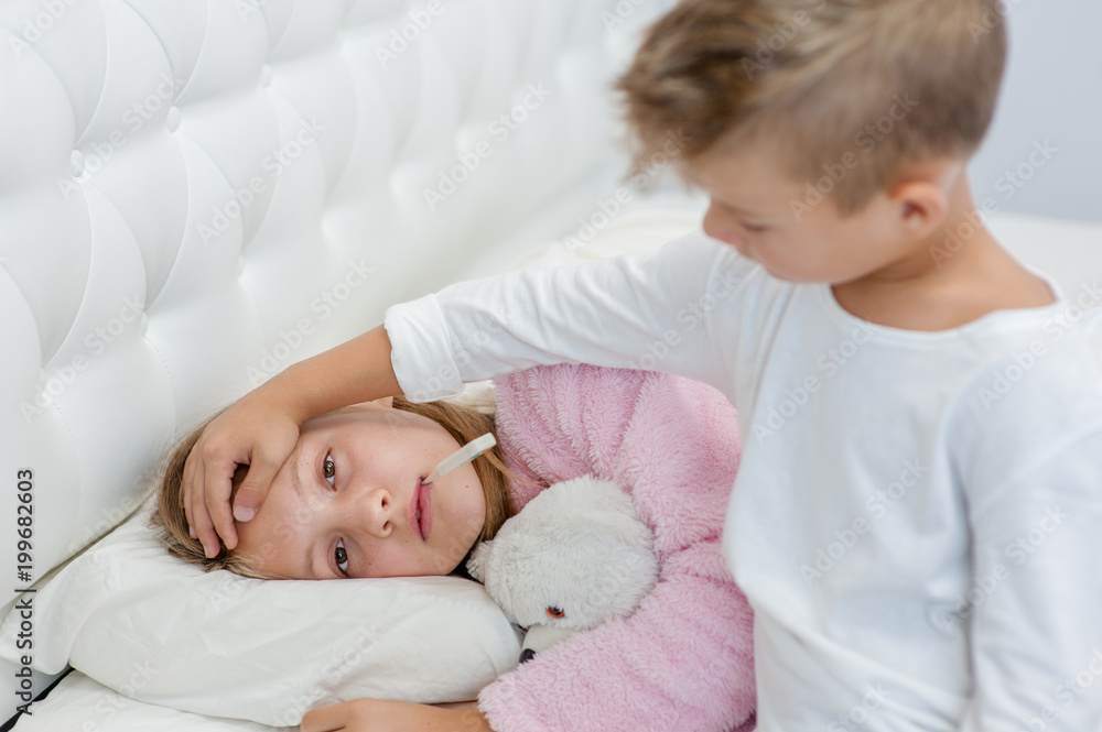 Brother touches his sister's forehead, checking the temperature Brother touches his sister's forehead, checking the temperature