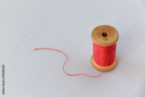 wooden coil with red thread. selective focus