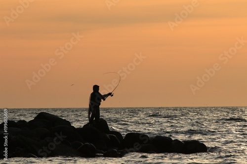 Angler auf Meerforelle auf einer Buhne an der Ostsee 