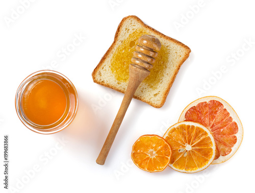 glass jar of honey and bread on white