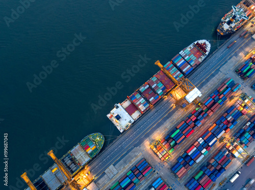 Aerial view of business port with shore crane loading container in container ship in import/export and business logistics with crane and shipping cargo.International transportation concept.