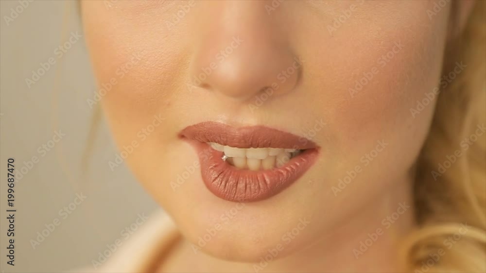 Blonde girl bites her lip and smiles Blonde girl bites her lip and smiles