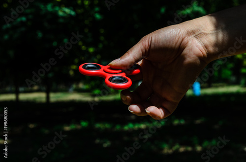 Red fidget spinner in female hand