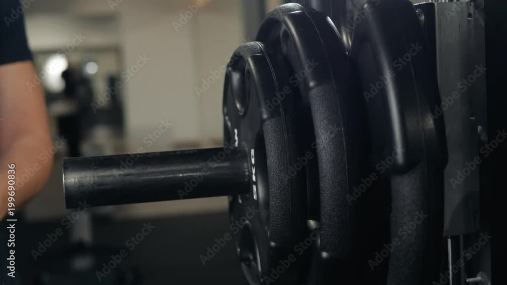 close up of handsome bodybuilder guy prepare to do exercises with barbell in a gym, keep barbell plate in hands macro super close up of handsome bodybuilder guy prepare to do exercises with barbell in a gym, keep barbell plate in hands macro super