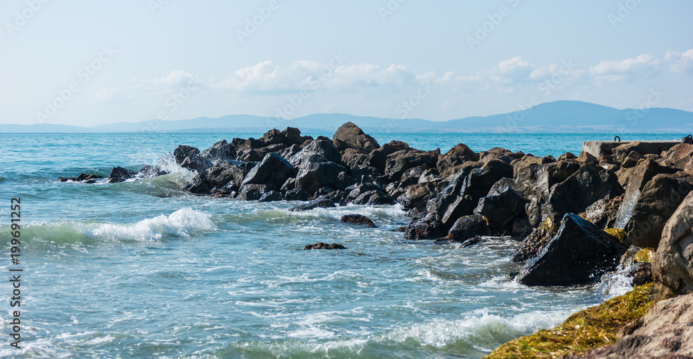 Rocky seashore. Small waves and stones.
