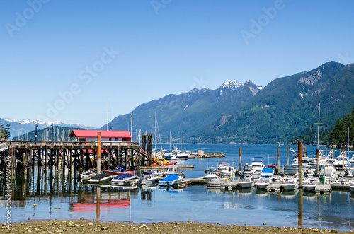 Boats in a Harbour along a Beautiful Bay Surrounded by Towering Forested Mountains on a Clear Summer Day. Horseshoe Bay, Vancouver, BC, Canada.
