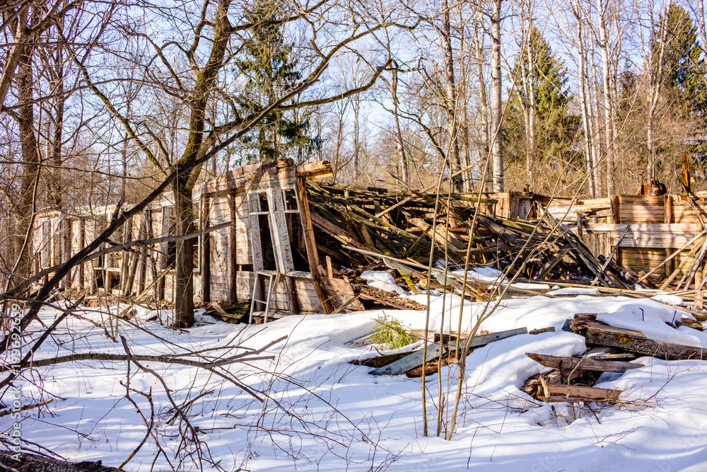 Demolished wooden structure in a forest area in winter. Former pioneer camp in Russia