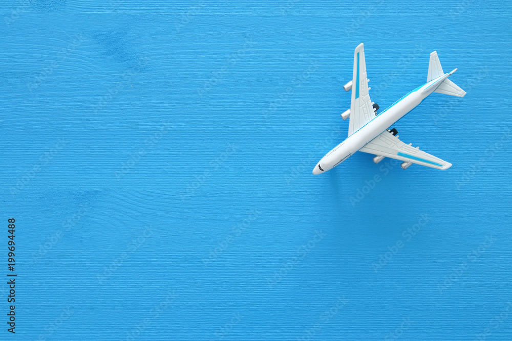 top view photo of toy airplane over blue wooden background.