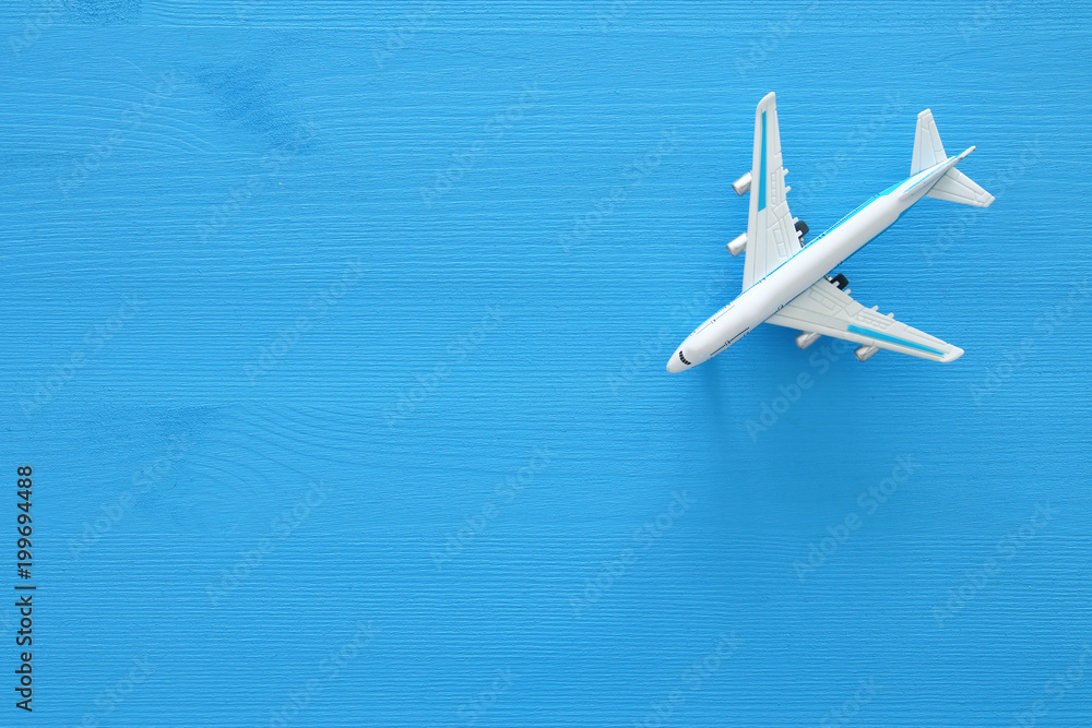 top view photo of toy airplane over blue wooden background. top view photo of toy airplane over blue wooden background.