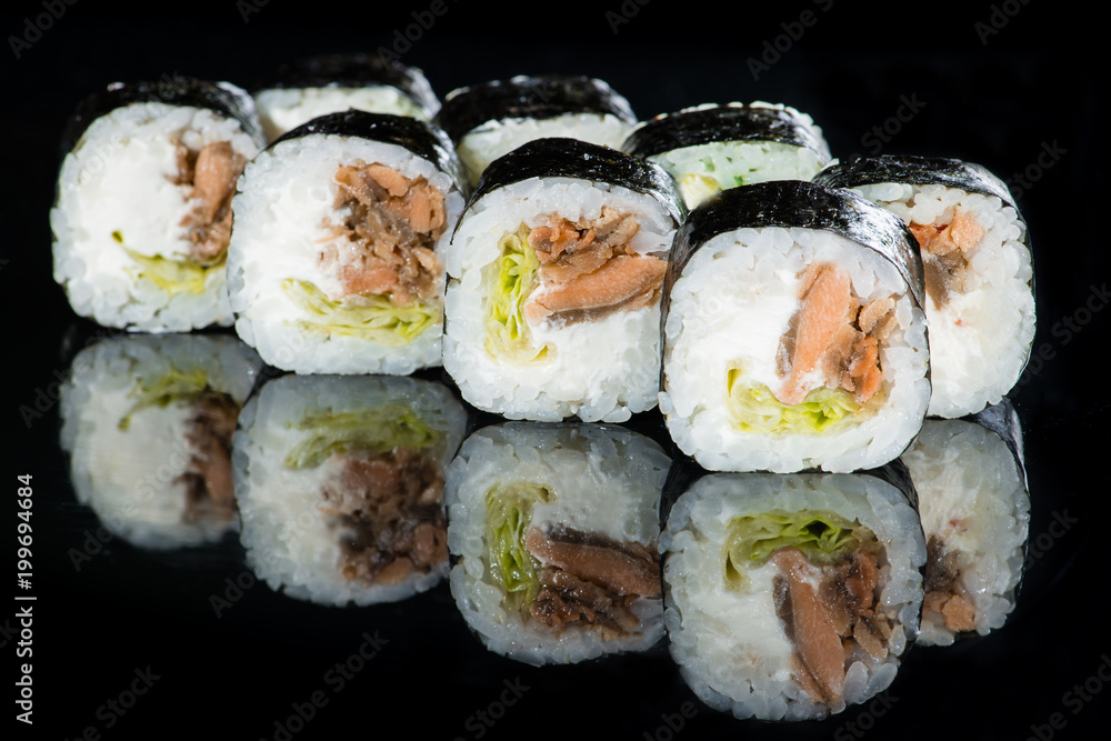 Japanese cuisine. Appetizing maki sushi rolls with rice, avocado, cucumber and shrimp on dark background Japanese cuisine. Appetizing maki sushi rolls with rice, avocado, cucumber and shrimp on dark background