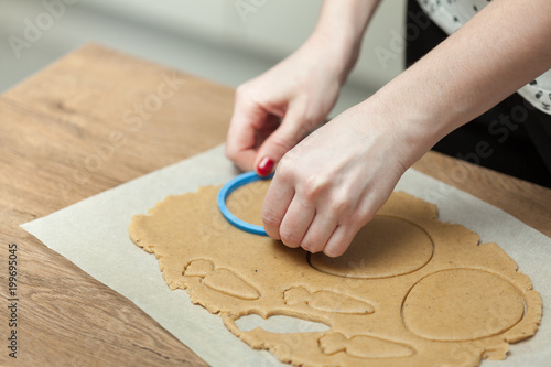 close up of female hands making cookies from fresh dough at home