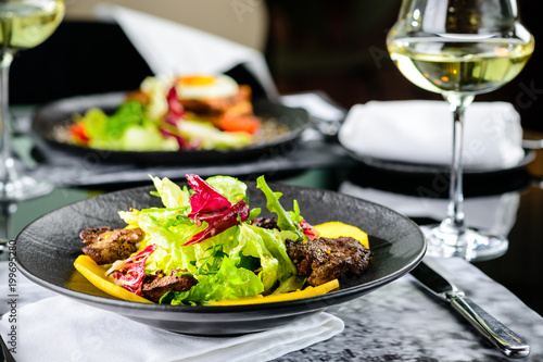 Tasty dish with juicy beef steak and fresh lettuce leaves at a restaurant