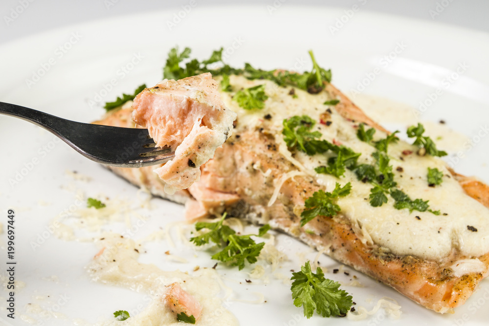 Fried Salmon with cheese sauce, parsley and pepper.