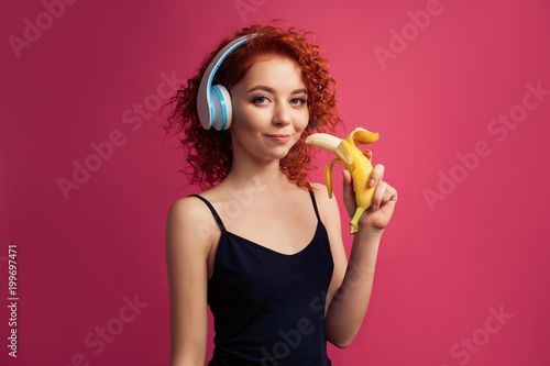 Smiling girl with Smartphone in the hands of the headphones and listens to music and communicates