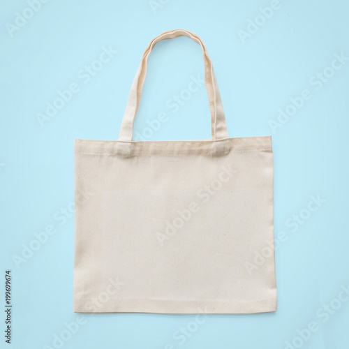 Tote bag mock up canvas white cotton fabric cloth for eco shoulder shopping sack mockup blank template isolated on pastel blue background (clipping path)
