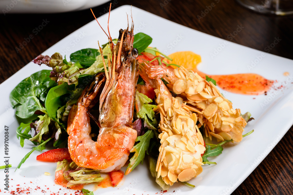 Romantic dinner at a restaurant. Delicious prepared shrimp with tomatoes, sauce and basil leaves. Romantic dinner at a restaurant. Delicious prepared shrimp with tomatoes, sauce and basil leaves.