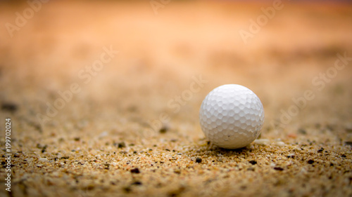 Soft golf ball on sand bunker in golf course