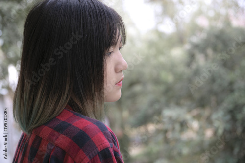 Portrait of Asian girl with looking at somewhere on nature background.