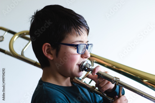 Menino a tocar trombone em casa.
