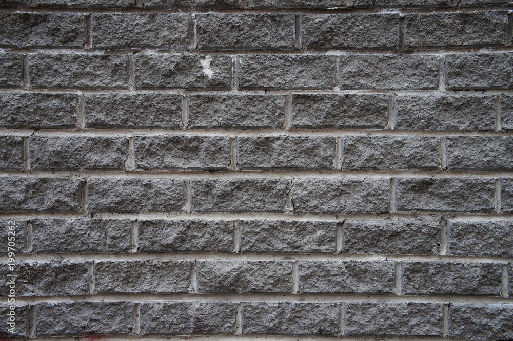 textured wall of gray brick blocks