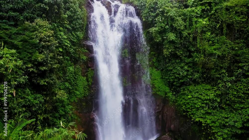 aerial shot with dron flying above beautiful Bali paradise waterfall and jungle rainforest in Asia travel destination and Summer vacations trip concept