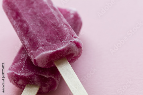 Raspberry flavour summertime ice lollies on a pink background