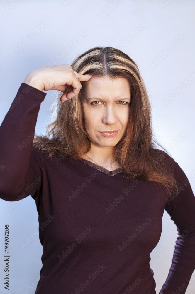 A beautiful woman shows a finger on her hair, which soon becomes gray A beautiful woman shows a finger on her hair, which soon becomes gray