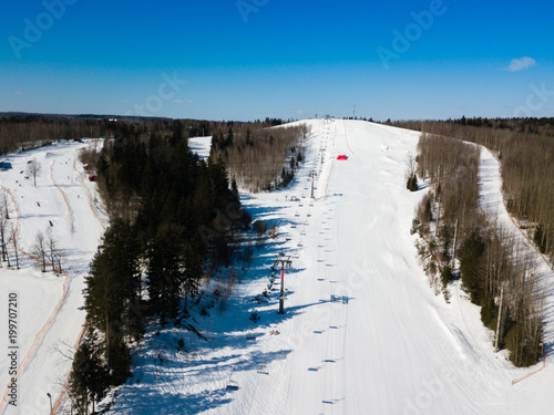 Active leisure and winter entertainment. Skiers and snowboarders riding on a ski slope at ski resort. Quadcopter view