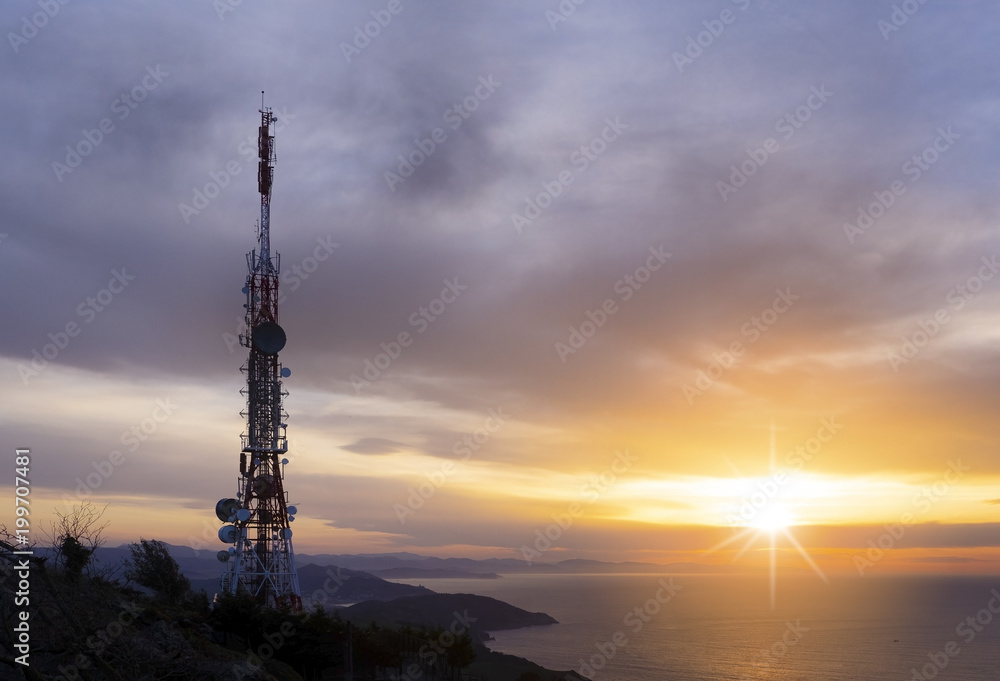 telecommunication tower with the sun as it beats over the sea telecommunication tower with the sun as it beats over the sea