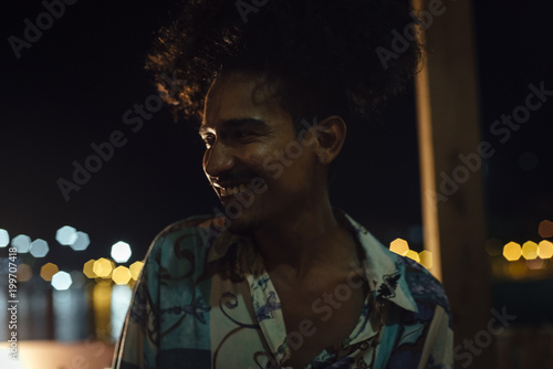 Close emotional moment of indian ethnicity afro hair DJ dancing in a tropical party in the caribbean sea in Santa Marta, Colombia photo