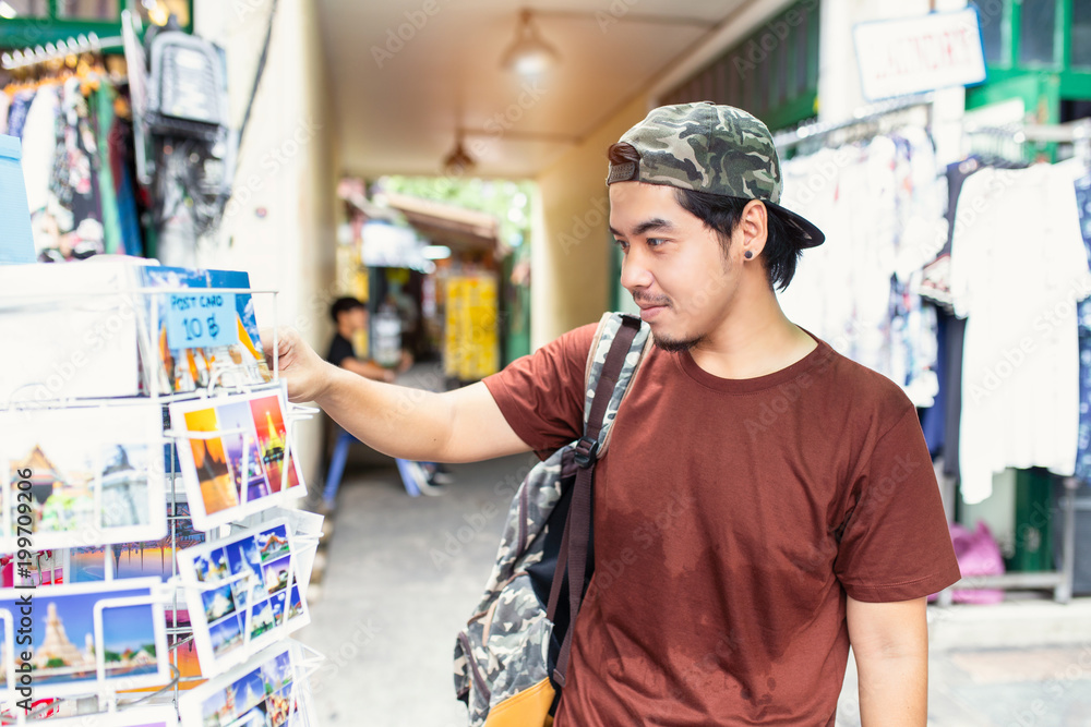 Fototapeta premium Japanese tourist enjoying sightseeing exploring city and buy postcards at Tha Pae Walking Street, Chiang mai Province, Thailand