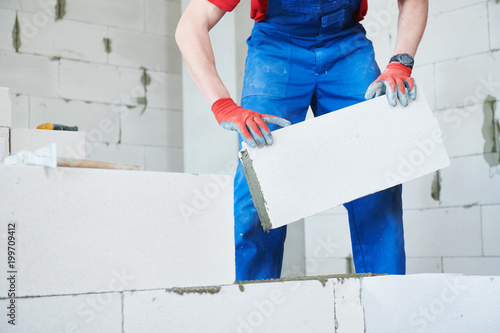 bricklayer builder working with autoclaved aerated concrete blocks. Walling photo