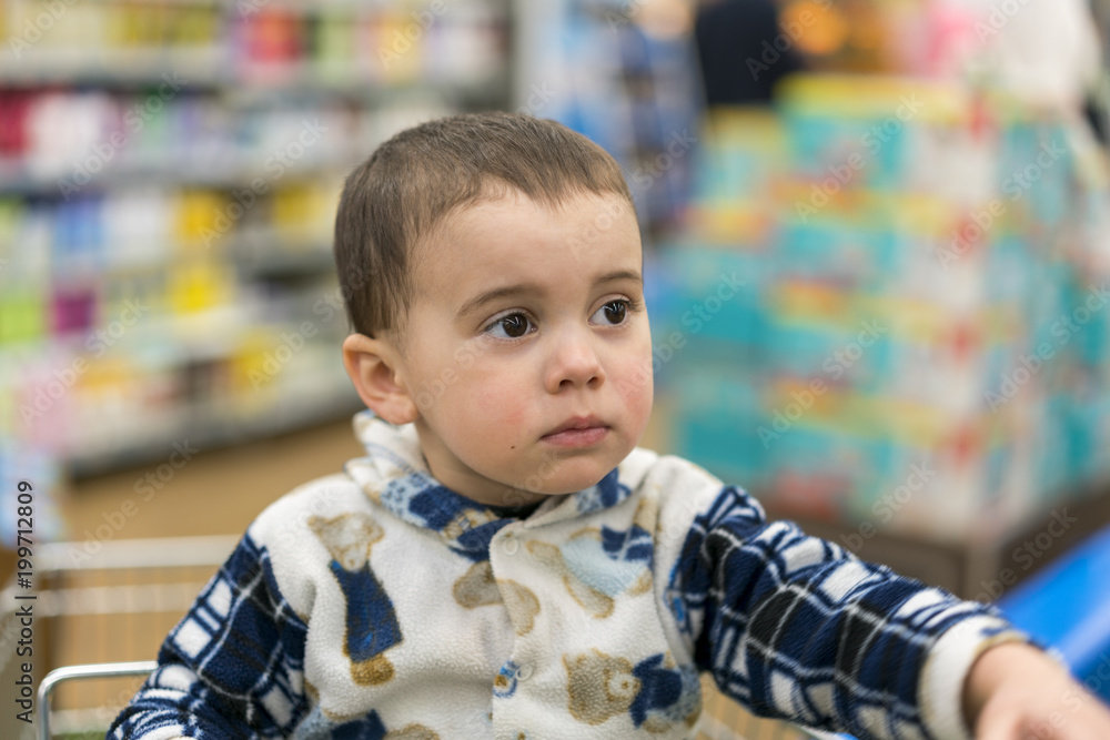 Sad little boy in the store. Sad babe in the supermarket Sad little boy in the store. Sad babe in the supermarket