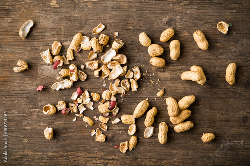 Unpeeled peanuts on wooden background with copyspace for text. Top view, flat lay