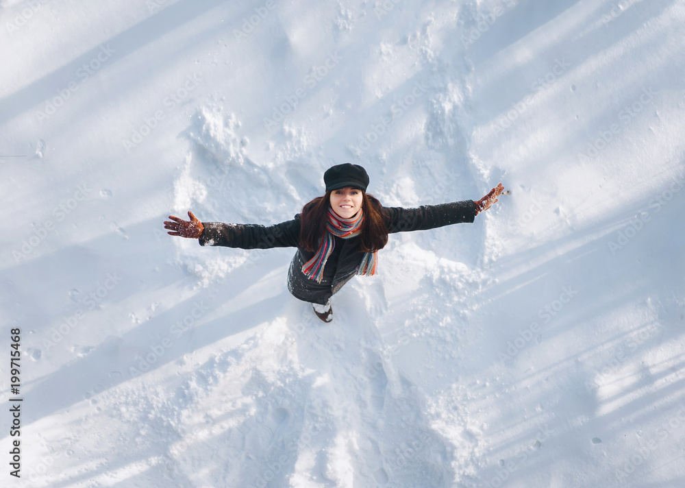 Snow angel concept. Angel wings on the snow. The girl spreading her arms. Snow angel concept. Angel wings on the snow. The girl spreading her arms.