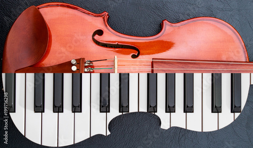 piano keys in to the violin on the black leather table, half keyboard like violin shape