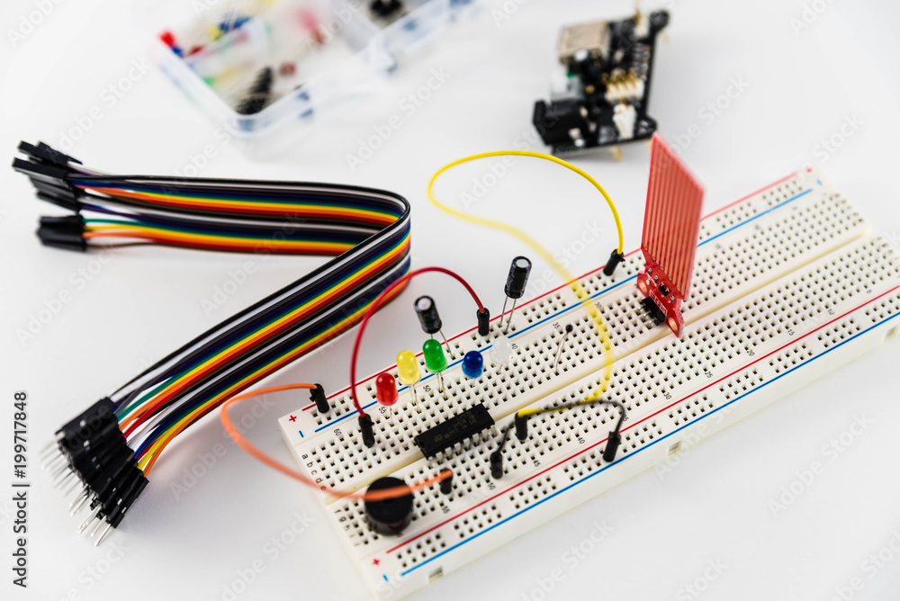 Microcontrollers, chips, resistors and light-emitting diodes on white desktop of hardware engineer. Engineer workplace