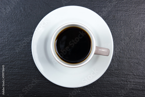 cup of coffee on black wooden background. Top view