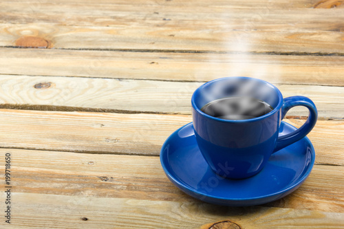 Blue cup of coffee on a wooden background.
