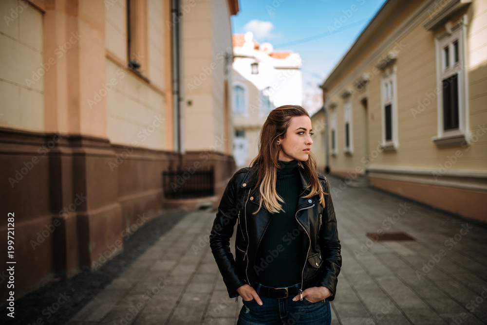 Fototapeta premium Young brunette woman walking european city streets.