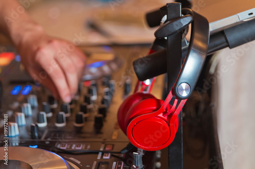 Dj mixer with headphones at nightclub . Dj mixes the track in the nightclub at party . DJ. sound equipment . © adilcelebiyev