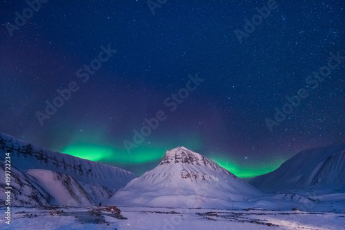 Fotobehang The polar arctic Northern lights aurora borealis sky star in Norway Svalbard in