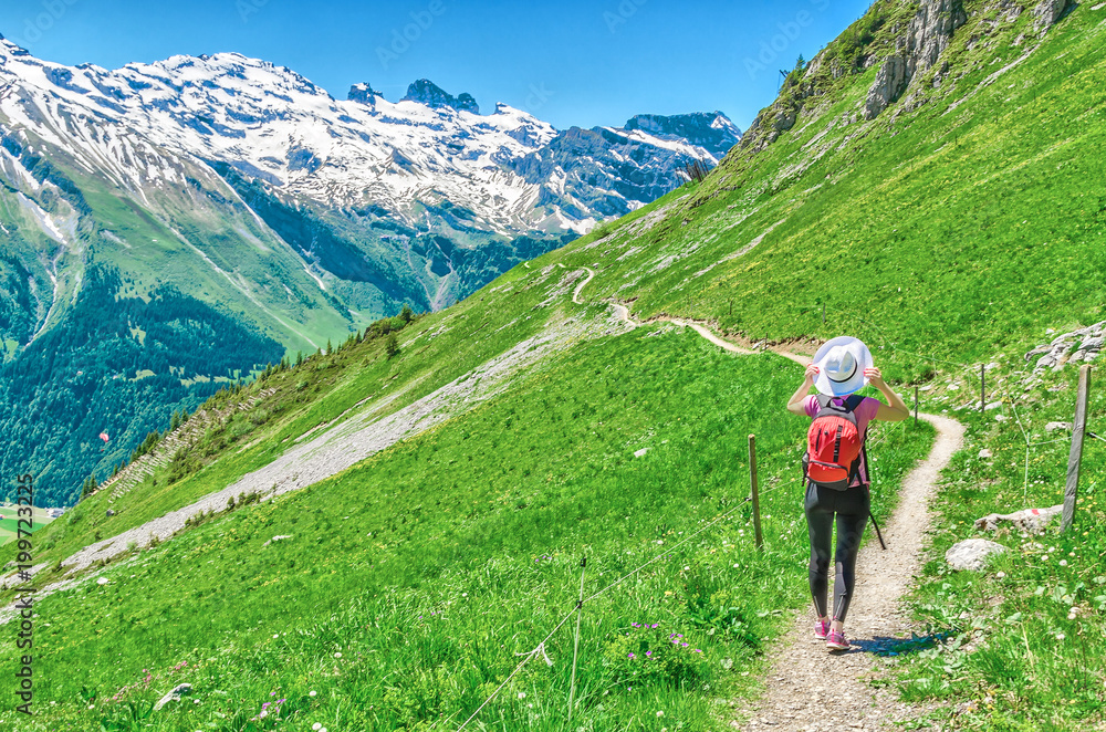 Swiss Alps. A man in a white hat, a traveler in a mountain alpine country walk along the path. Landscape of the Swiss Alps, Engelberg Resort