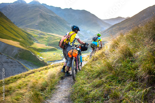 Biker pushes his bicycle up in high Caucasus mountains